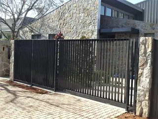 Black sliding driveway gate with closely spaced vertical bars