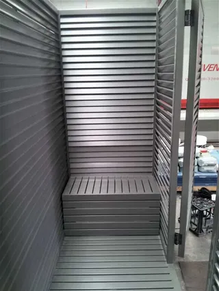 Louvred metal enclosure with an internal shelf
