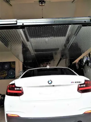 Perforated metal platform installed above a parked car