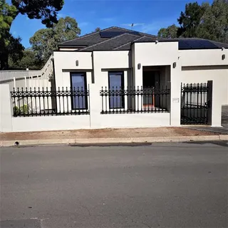 Black metal front fence and gates across a modern home