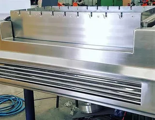 Close view of a stainless steel barbecue grill and splashback