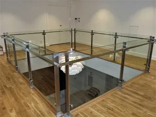 Stainless steel posts and glass balustrade around an upstairs void