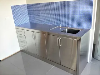 Stainless steel sink cabinet and benchtop against blue tiles