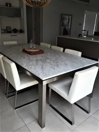 Dining table with a marble top and stainless steel frame