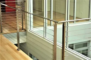 Stainless steel cable balustrade beside an indoor stairwell