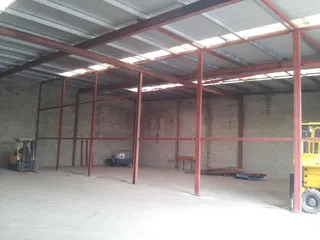 Red structural steel posts and beams inside a warehouse