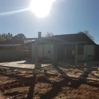 Grey steel extension frame beside a house under construction
