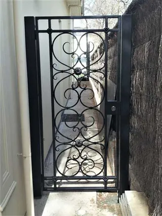 Narrow decorative wrought iron side gate