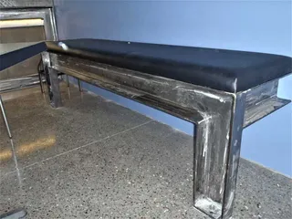 Black upholstered bench on a fabricated steel frame