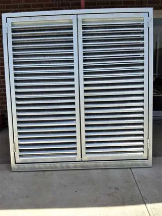 Double louvred metal doors in a rectangular frame