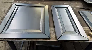 Folded sheet-metal panels laid out on a workshop bench
