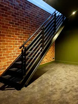 Black steel staircase and horizontal balustrade in a finished interior