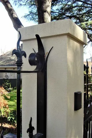 Close view of spearhead and scroll details on a wrought iron fence
